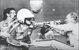  ?? Associated Press ?? BOBBY ALLISON, center, and his brother Donnie fight Cale Yarborough after a last-lap collision knocked Donnie out of the lead, thus ending his chances of a win.