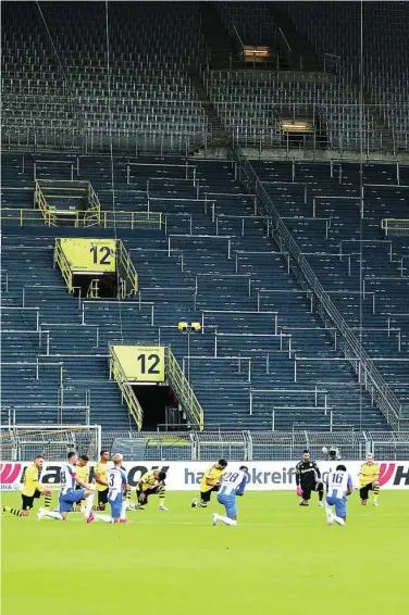  ??  ?? Los jugadores del Dortmund y del Hertha, con la rodilla en tierra antes de empezar el encuentro