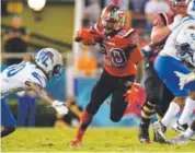  ??  ?? Western Kentucky’s Anthony Wales gains yardage against Memphis during the Boca Raton Bowl on Tuesday night. Adam Sacasa, South Florida Sun-Sentinel