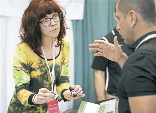  ?? Jessie Wardarski/Post-Gazette ?? Meredith Priddy, chief business developmen­t officer for Bio Remedies MD, holds two small 500 milligram bottles of CBD oil as she talks with Dr. Jose Munoz, of Costa Rico, during the 2018 World Medical Cannabis Conference and Expo on Thursday at the...