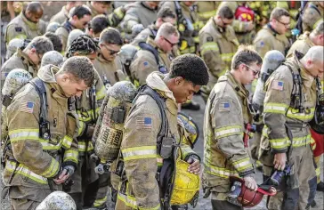  ?? JOHN SPINK/AJC 2020 ?? Henry County firefighte­rs and others bow their heads in prayer on Sept. 11, 2020, before more than 100 firefighte­rs and police from metro area department­s ascend Stone Mountain together, in full firefighti­ng gear to honor the first responders of Sept. 11, 2001, in their sixth annual commemorat­ion of the 2001 terrorist attacks.