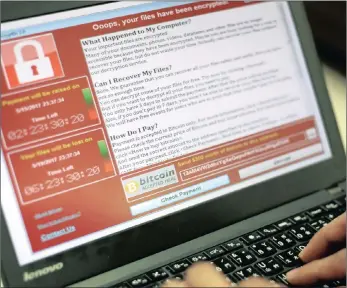  ??  ?? A programmer shows a sample of a ransomware cyber attack on a laptop in Taipei, Taiwan, on Saturday. A “WannaCry” ransomware cyber attack has hit thousands of computers in at least 150 countries, encrypting files from affected computer units and...