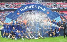  ??  ?? Chelsea's Italian head coach Antonio Conte (R) sprays champagne as his players celebrate with the trophy after their victory in the English FA Cup final.