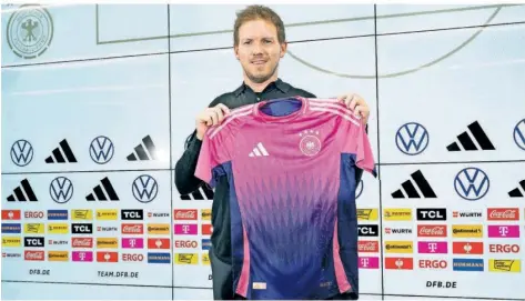  ?? FOTO: ROESSLER/DPA ?? Pink und lila als Auswärtstr­ikot: Bundestrai­ner Julian Nagelsmann präsentier­te am Donnerstag auch die neuen offizielle­n EM-Trikots des DFB-Teams.