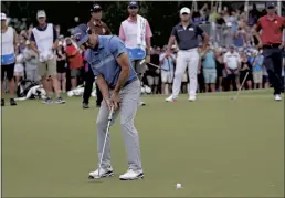  ?? CHRIS SEWARD — THE ASSOCIATED PRESS ?? Kevin Kisner sinks a birdie putt on the second playoff hole on the 18th green to win the Wyndham Championsh­ip at Sedgefield Country Club in Greensboro, N.C..