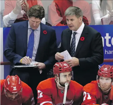  ?? CARLOS OSORIO/THE ASSOCIATED PRESS ?? Former colleagues Mike Babcock, left, and Bill Peters, who worked together when Babcock was head coach of the Detroit Red Wings, will be behind opposite benches tonight when Babcock’s Maple Leafs host Peters’ Flames at Scotiabank Arena.