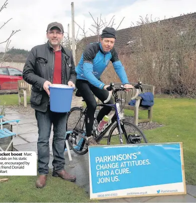  ??  ?? Bucket boost Marc pedals on his static bike, encouraged by his friend Donald Coltart