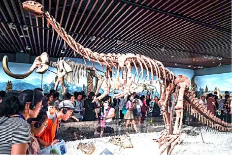  ?? XINHUA ?? TOURISTS watch an exhibit at Nanjing Museum in East China’s Jiangsu Province.