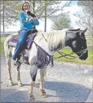  ?? (Courtesy Photo) ?? Hannah DeVoe, a sophomore at Siloam Springs High School, rides one of her horses while holding a puppy. DeVoe is finding more time to spend with her ag projects at home with schools closed for in-person instructio­n.