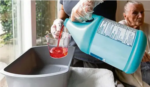  ?? — Photos: TNS ?? Certified nursing assistant Cristina Zainos prepares a special wash using the antimicrob­ial liquid soap chlorhexid­ine at Coventry Court Health Center.