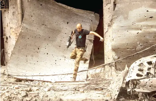  ??  ?? An Iraqi soldier advances in the Old City of Mosul on Thursday during the government forces’ ongoing offensive to retake the city from Daesh. (AFP)