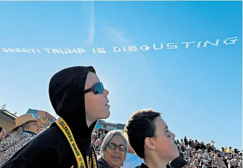  ??  ?? Spectators at the Rose Parade in Pasadena, California, on New Year’s Day, where skywriters created the message: ‘America is great; Trump is disgusting’ above the route
