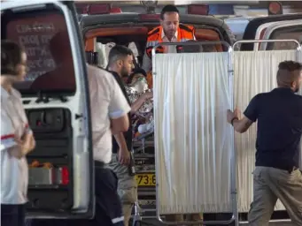  ?? (Reuters) ?? Medics evacuate an Israeli woman who was injured during a knife attack