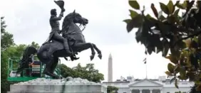  ?? JACQUELYN MARTIN/AP PHOTO ?? A National Park Service worker cleans a statue of President Andrew Jackson using fire earlier this month.