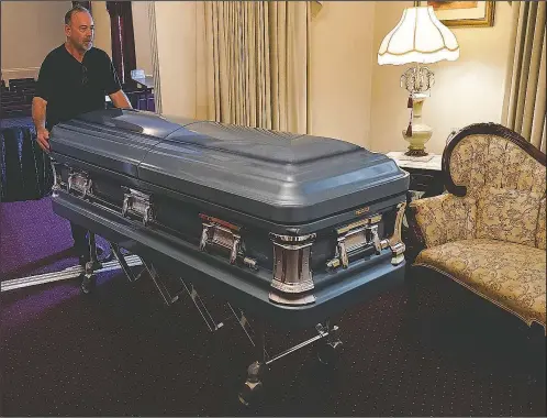  ?? (File Photo/ap/john Raoux) ?? Callahan Funeral Home director Ellis Mcaninich moves a casket Aug. 10 for display to a room in the home in Callahan, Fla. Mcaninich has overseen funerals for five people who died from the virus since July. He recovered from a bout with the virus and now plans to get vaccinated. On Friday, The Associated Press reported on stories circulatin­g online incorrectl­y asserting covidd-19 vaccines are more deadly than the virus itself. In fact, reports of death resulting from vaccinatio­ns are rare while more than 4 million people worldwide have died from covid-19.