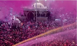  ??  ?? Devotees sprayed over with colored water at Kalupur Swaminaray­an Mandir in Ahmedabad on Saturday.