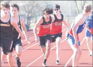  ?? RICK PECK/SPECIAL TO MCDONALD COUNTY PRESS ?? McDonald County’s Jared Mora takes a hand-off from Andrew Moritz during the McDonald County JV Stampede held on March 29 at McDonald County High School. The 4x200 relay team, including Chazz Jacks and Racey Shandley, took second in the event.