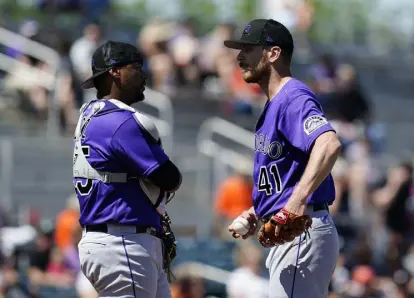  ?? Ross D. Franklin, The Associated Press ?? Colorado starting pitcher Chad Kuhl (41) gets a visit from catcher Elias Diaz during a spring training game against the San Francisco Giants on Thursday.