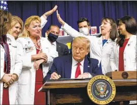  ?? Alex Brandon Associated Press ?? SUPPORTERS celebrate as President Trump signs four executive orders on lowering drug prices Friday, his latest attempt to fulfill a 2016 campaign promise.