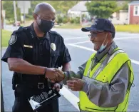  ?? ?? Greensboro Police Chief Brian James shakes hands with Faucette after presenting him with an award during his birthday celebratio­n in Greensboro.