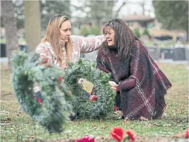  ?? PETER POWER FOR THE TORONTO STAR ?? Breanna Mondy, left, comforts her mother, Dawn Girard, after they laid homemade Christmas wreaths at the graves of her Girard’s brothers at Mountview Cemetery in Cambridge, Ont. Her siblings died of opioid overdoses.