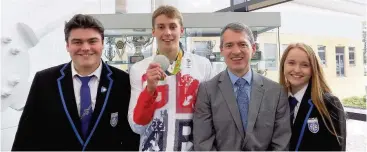  ??  ?? Olympic hero GB silver medallist Stephen Milne was greeted at Carluke High School by captains Hannah Pelling and Harry Richardson, with headmaster Andy Smith