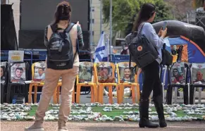  ?? HANNAH MCKAY/REUTERS ?? People stand in front of an installati­on in Tel Aviv, Israel, in support of hostages kidnapped in the deadly Oct. 7 attack on Israel by the Palestinia­n Islamist group Hamas.