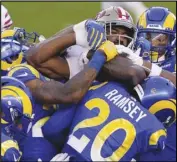  ?? Associated Press ?? HERD MENTALITY San Francisco 49ers running back Raheem Mostert, center, is tackled by a herd of Los Angeles Rams defenders during the first half in Santa Clara on Sunday. The 49ers won 24-16.