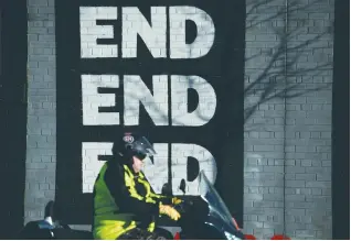  ?? (Reuters) ?? A MOTORCYCLE pases a mural on Belfast’s Falls Road yesterday, a day after Northern Ireland’s Deputy First Minister Martin McGuinness resigned, throwing the devolved joint administra­tion into crisis.