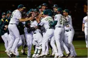  ?? JASON O. WATSON / GETTY IMAGES ?? Mike Fiers of the A’s celebrates with teammates after pitching a no-hitter against the Reds on May 7. His solo feat is becoming even rarer.