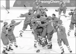  ?? HARRY HOW/GETTY ?? Russian team members fling away their gloves and sticks and join in celebratin­g their gold medal in hockey after beating Germany on Kirill Kaprizov’s goal in overtime.