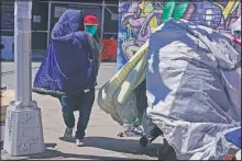  ??  ?? Sotero Cirilo airs out a sleeping bag at the homeless encampment where he sleeps.