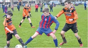  ??  ?? A Dundee West player (stripes) fights to keep the ball in the U/14s League Cup clash with DUSC.