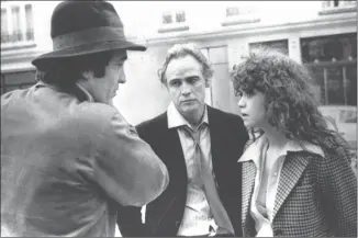  ?? The Associated Press ?? In this 1973 file photo, Italian director Bernardo Bertolucci, left, discusses a scene with leading actor Marlon Brando, center, and actress Maria Schneider during the shooting on the movie “Last Tango in Paris.”