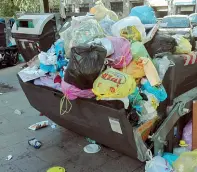  ??  ?? L’emergenza
Un cassonetto rovesciato per i rifiuti e la raccolta difficolto­sa a Roma