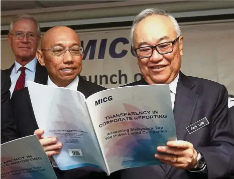  ??  ?? Minister in the Prime Minister’s Department Datuk Paul Low and Malaysian Institute of Corporate Governance president Datuk Yusli Mohamed Yusof (second from left) looking at the inaugural report on “Transparen­cy in Corporate Reporting” that was launched...