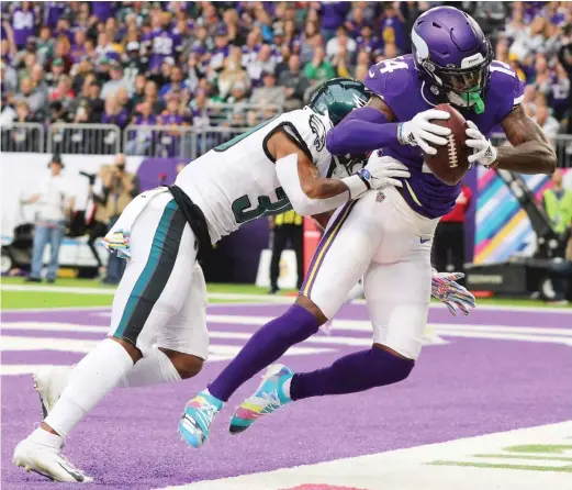  ?? ADAM BETTCHER/GETTY IMAGES ?? Vikings receiver Stefon Diggs hauls in one of his three touchdown catches behind Eagles cornerback Craig James on Sunday.
