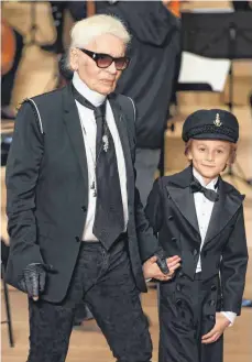  ?? FOTO: AFP ?? Nimm mich mit, Kapitän, auf die Reise: Karl Lagerfeld und sein neunjährig­er Patensohn Hudson Kroenig beim Auftritt in Hamburg.