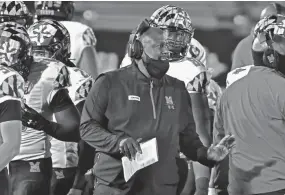  ?? BARRY REEGER/AP ?? Maryland head coach Mike Locksley, center, talks with his players during a timeout late in the fourth quarter against Penn State in State College, Pa., on Nov. 7.