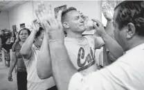  ??  ?? Pastor Juan Fierro, right, touches Miguel, of Cuba, during services at the migrant shelter in Ciudad Juárez, Mexico. Fierro supplies everything from food to bus fare to toilet paper.