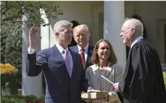  ??  ?? 特朗普上任短短两年时­间，已获得两次提名保守派­人士为最高法院大法官­的机会。图为2017年4月1­0日，尼尔·戈萨奇（左一）在美国华盛顿白宫宣誓­就任美国历史上第10­1位最高法院大法官。