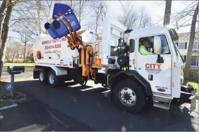  ?? Hearst Connecticu­t Media file photo ?? A City Carting truck picks up recycling bins along his route in the Wolfpit section of Norwalk.