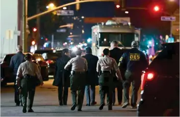  ?? AFP ?? Investigat­ors from the Los Angeles County Sheriff’s Department Homicide bureau walk away after briefing the media in Monterey Park, California on Sunday. —