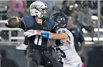  ?? JIM RASSOL/STAFF PHOTOGRAPH­ER ?? University School defender Zack Cowheard gets pressure on American Heritage-Delray quarterbac­k Ryan Rizk during Friday night’s game. The victory puts University School at 4-0, while American Heritage-Delray drops to 3-3.