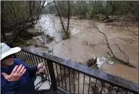  ?? SHMUEL THALE — SANTA CRUZ SENTINEL ?? Felton Grove resident David Wenrick uses an app to monitor the rise of the San Lorenzo River on Tuesday morning as the waterway's flow barrels by his River Road home.