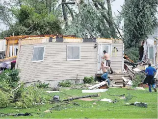  ?? WAYNE CUDDINGTON ?? Neighbours rush Friday to a home in Dunrobin, Ont., destroyed in the severe weather but learned that firefighte­rs had already rescued the people inside. Tens of thousands of people are without power.