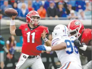  ?? The Associated Press ?? SMASHING PERFORMANC­E: Georgia quarterbac­k Jake Fromm (11) looks to throw a pass as Florida defensive lineman Cece Jefferson, right, rushes during the first half of the Bulldogs’ 36-17 win against the Gators on Saturday in Jacksonvil­le, Fla.