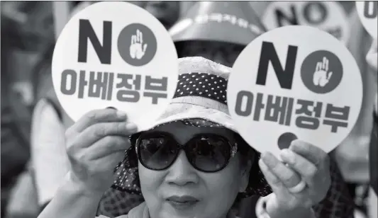  ?? Photo: AFP ?? A South Korean protester holds up signs reading “NO to Abe government” during an anti-Japanese rally in Seoul on Tuesday. South Korea on Monday put Japan into its own new export category as President Moon Jae-in called Tokyo’s latest measures “very serious,” intensifyi­ng a trade war between the two neighbors and US allies.