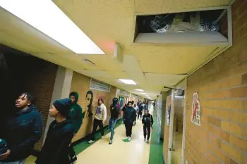  ?? ROGELIO V. SOLIS/AP ?? Jim Hill High School students walk past an open vent of the school’s HVAC system Jan. 12 in Jackson, Miss.