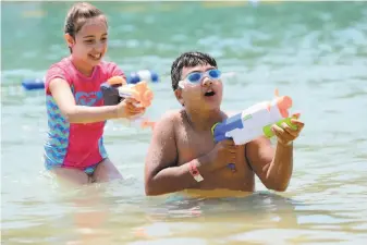  ?? Michael Macor / The Chronicle ?? Jaelynn Thomas, 9, of Hayward ambushes Kekoa Juvera, 12, while playing in Don Castro Regional Park in Castro Valley, where temperatur­es climbed to 93.